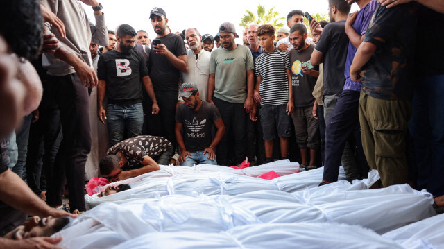 Des Palestiniens entourent les corps des victimes d'une frappe israélienne qui a visé une mosquée transformée en abri à Deir al-Balah, dans le centre de la bande de Gaza, dans la cour de l'hôpital des Martyrs d'al-Aqsa, le 6 octobre 2024, dans le cadre de la guerre entre Israël et le mouvement palestinien Hamas. L'agence de défense civile de Gaza a déclaré le 6 octobre qu'une frappe israélienne sur la mosquée transformée en abri dans le centre de Deir al-Balah avait tué 21 personnes, tandis que l'armée israélienne a déclaré qu'elle avait visé des militants du Hamas.