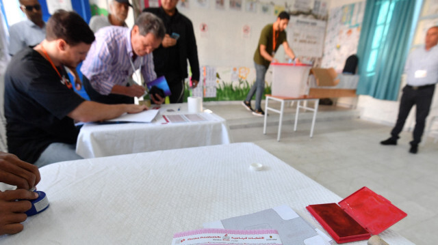 Un bulletin de vote avec les trois candidats à l'élection présidentielle tunisienne est posé sur une table dans un bureau de vote à Tunis le 6 octobre 2024. Les élections présidentielles tunisiennes ont débuté le 6 octobre, sans réelle opposition au président sortant Kais Saied, qui est largement pressenti pour gagner, ses principaux détracteurs étant derrière les barreaux.