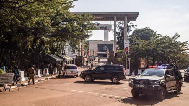 Une voiture de patrouille de la police ougandaise passe devant l'entrée du Parlement avant une manifestation anti-corruption prévue à Kampala le 23 juillet 2024.