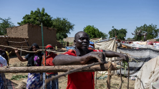 Un homme construit un abri de fortune dans le camp improvisé près de la digue de Ndou, dans le sud-est du neuvième arrondissement de Ndjamena, le 8 octobre 2024, après avoir été déplacé par la crue du fleuve Logone qui a inondé le quartier de Tougoudé, à N'Djamena.