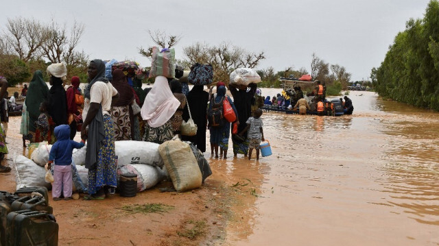 Cette photographie prise le 20 août 2024 montre des bateaux de police utilisés pour transporter des personnes suite aux fortes pluies qui ont endommagé la route nationale 25 reliant la capitale nigérienne Niamey aux provinces de Tillabéri et Tahoua dans l'ouest du Niger. 