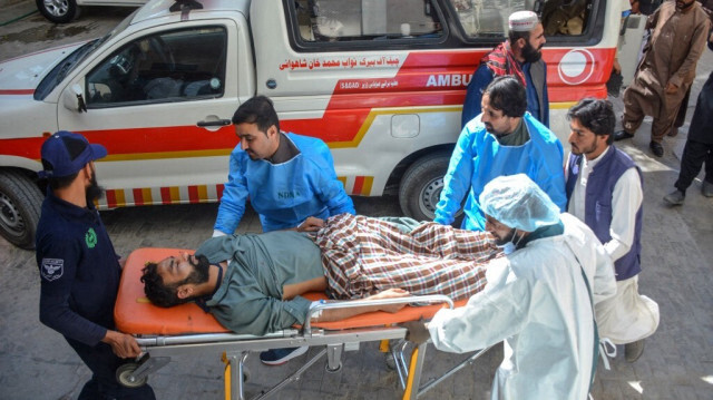 Des ambulanciers et d'autres personnes transportent un blessé à l'hôpital après une explosion près d'une école de filles visant la police qui gardait les vaccinateurs contre la polio dans la ville de Mastung, dans la province du Baloutchistan, le 1er novembre 2024.