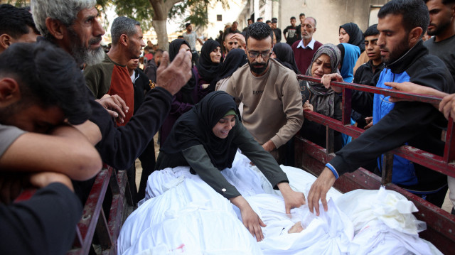 Une femme réagit alors que des Palestiniens entourent des corps alignés à l'arrière d'une camionnette, dans la cour de l'hôpital al-Shifa de la ville de Gaza, après que les corps des victimes y ont été transportés, suite à une frappe israélienne qui a touché une école transformée en abri dans le camp de réfugiés d'Al-Shati, le 7 novembre 2024, dans le cadre de la guerre en cours entre Israël et le groupe militant du Hamas.