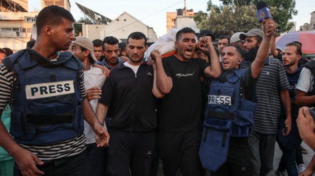 Des personnes en deuil et des collègues portent le corps du journaliste d'Al-Jazeera Arabic Ismail al-Ghoul, tué avec son caméraman Rami al-Refee lors d'une frappe israélienne pendant leur couverture du camp de réfugiés d'Al-Shati à Gaza, le 31 juillet 2024. Al Jazeera a condamné l'assassinat de deux de ses journalistes, qualifiant ces décès d'"assassinat de sang-froid" dans un communiqué.