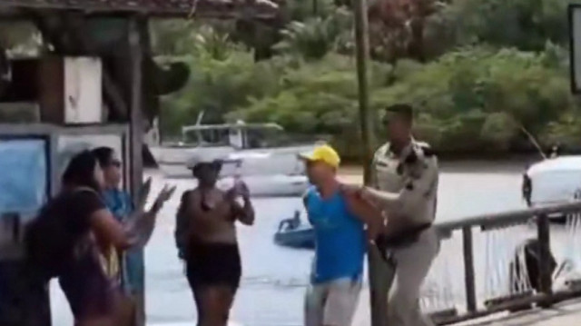 Un policier procède à l'arrestation d'un touriste israélien accusé de tentative de corruption et d'injures racistes.