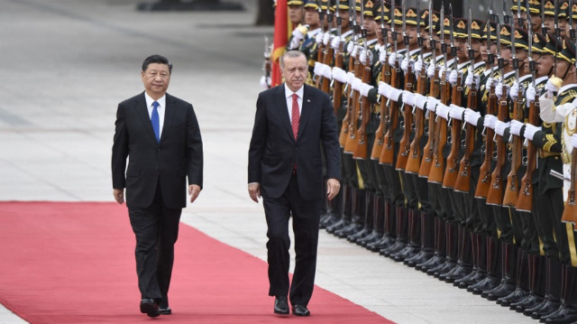 Le président turc Recep Tayyip Erdogan (à droite) et le président chinois Xi Jinping (à gauche) inspectent les gardes d'honneur chinois lors d'une cérémonie de bienvenue à l'extérieur du Grand Hall du Peuple à Beijing, le 2 juillet 2019.