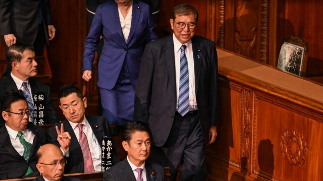 Le Premier ministre japonais Shigeru Ishiba (à droite) descend pour rejoindre la file d'attente afin de voter au second tour d'un vote parlementaire visant à nommer un Premier ministre à la suite des élections générales du 27 octobre, lors d'une session spéciale du Parlement à Tokyo, le 11 novembre 2024.