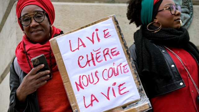 Une manifestante brandit une pancarte lors d'un rassemblement organisé par la diaspora française d'outre-mer contre le coût élevé de la vie, sur la place Denfert-Rochereau à Paris, le 10 novembre 2024.