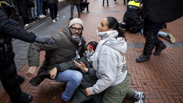 Des manifestants portent secours à un autre manifestant pro-palestinien blessé près de la place du Dam, lors d'une mobilisation en soutien à Gaza à Amsterdam, le 10 novembre 2024.