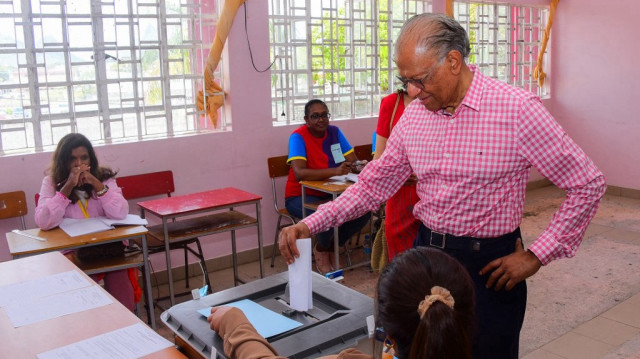 L'ancien Premier ministre mauricien et candidat de l'Alliance du Changement, Navin Ramgoolam (R), vote lors des élections générales mauriciennes de 2024 dans un bureau de vote à Port Louis, le 10 novembre 2024. 