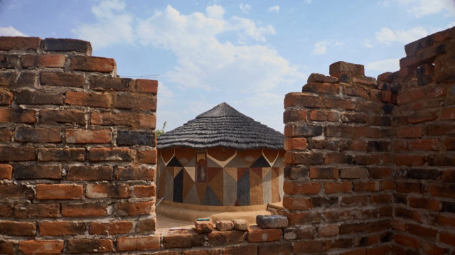 Vue générale d'une maison peinte en boue à travers la fenêtre d'une maison en construction à Matobo, Matabeleland, le 29 septembre 2024. 