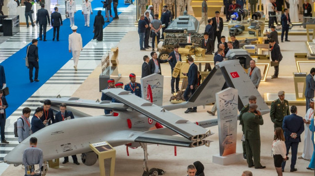 Des visiteurs regardent un système aérien sans pilote armé Bayraktar TB3 exposé à l'exposition UMEX qui présente les drones, la robotique et les systèmes sans pilote au Centre national des expositions d'Abu Dhabi, à Abu Dhabi, le 23 janvier 2024.