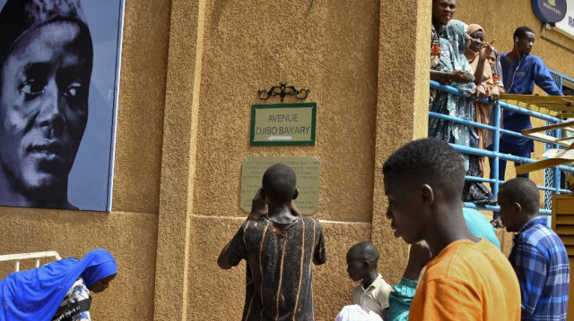 Cette photo prise à Niamey le 15 octobre 2024 montre des enfants devant la nouvelle plaque où l'avenue Général Charles de Gaulle a été rebaptisée en avenue Djibo Bakary, du nom de la personnalité politique nigérienne (1922-1998) qui fut le premier maire de Niamey (1956-1958).