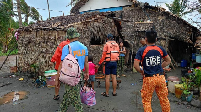 Des sauveteurs allant chercher des habitants lors d'une opération d'évacuation forcée dans la ville de Buguey, dans la province de Cagayan, au nord de Manille, avant que le super typhon Usagi n'atteigne les côtes, le 14 novembre 2024.