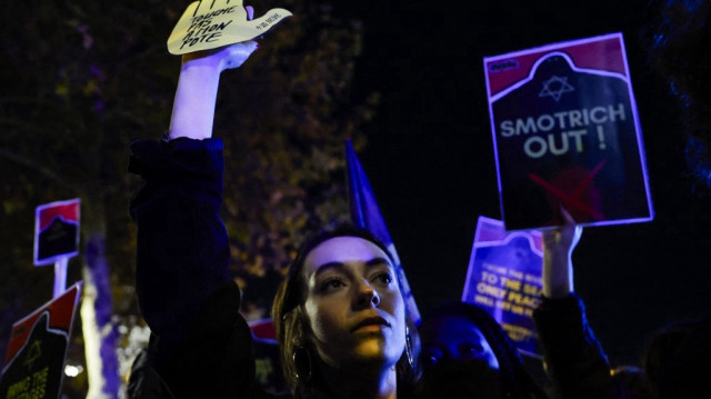 Une femme tient une pancarte lors d'un rassemblement contre le gala "Israel is forever" organisé par des personnalités franco-israéliennes d'extrême droite, à Paris, le 13 novembre 2024, à la veille du match de football de l'UEFA Nations League 2025 entre la France et Israël.