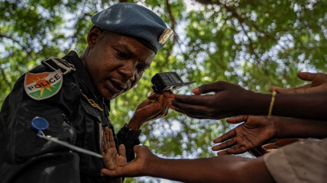 Ibrahim Daoussane, un officier de police nigérien appartenant à la MINUSCA, distribue des bonbons aux enfants dans un camp de personnes déplacées à Birao, le 13 août 2024. 