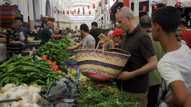 Des Tunisiens regardent des légumes exposés sur un étal au marché central de Tunis.