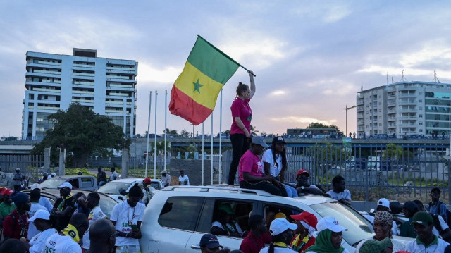 Le Premier ministre sénégalais et les partisans du parti Pastef, dont l'un tient un drapeau national sur une voiture, à Dakar, le 12 novembre 2024.