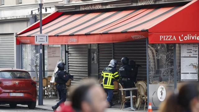 Des officiers de police se tiennent devant le restaurant "Pizza L'Olivier" à Issy-les-Moulineaux, en banlieue de Paris, le 16 novembre 2024.