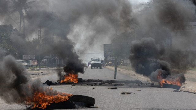 Des barricades enflammées sont visibles sur la route lors d'une manifestation dans le quartier de Choupal à Maputo, le 15 novembre 2024.