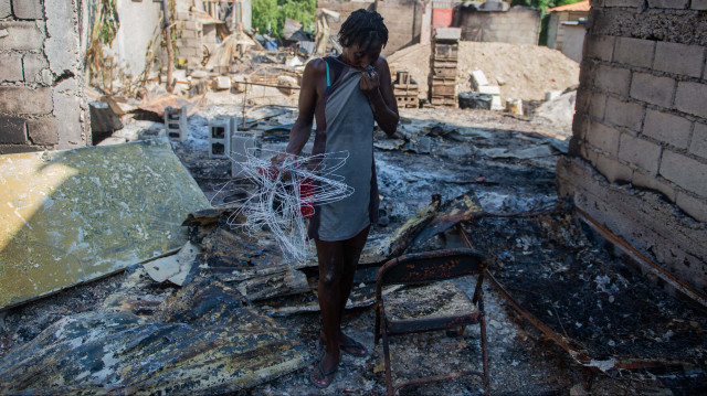 Une femme regarde les restes brûlés de sa maison dans le quartier de Solino à Port-au-Prince le 16 novembre 2024, un jour après que les gangs aient pris le contrôle de la zone. Le 13 novembre 2024, le quartier de Solino est tombé sous le contrôle de l'alliance de gangs "Viv Ansanm" ("Vivre ensemble"), qui s'est formée en février et a œuvré à l'éviction de l'ancien Premier ministre haïtien Ariel Henry, qui a démissionné de son poste en avril.