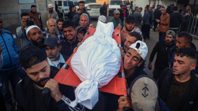 Des personnes en deuil portent le corps d'une victime d'une frappe israélienne, lors de funérailles à l'hôpital des Martyrs d'Al-Aqsa à Deir Al-Balah, dans le centre de la bande de Gaza, le 15 novembre 2024, dans le cadre de la guerre entre Israël et le groupe militant palestinien du Hamas.