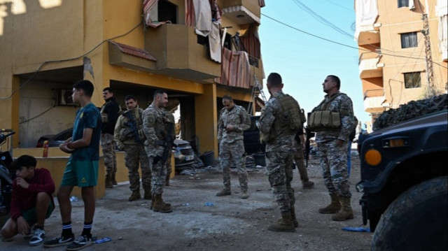 Des soldats libanais se tiennent à côté d'un bâtiment endommagé sur le site d'une frappe israélienne au Liban.