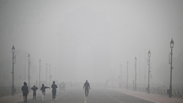 Des piétons marchent le long du chemin Kartavya, englouti dans un épais smog, près de la Porte de l'Inde à New Delhi, le 18 novembre 2024.