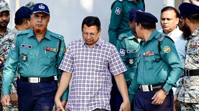 Des policiers escortent les détenus Chowdhury Abdullah Al-Mamun (C), ancien inspecteur général de police, et Ziaul Ahsan (dos, 2R), ancien général militaire et ancien directeur général du Centre national de surveillance des télécommunications (NTMC), devant le Tribunal pénal international (TPI) du Bangladesh, à Dhaka, le 20 novembre 2024. 