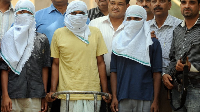 Des officiers de la cellule spéciale (à l'arrière-plan) montrent trois présumés naxalites, Satish Kumar (3L), Yogendra (2L) et Shetal Kumar (L), à des journalistes à New Delhi.