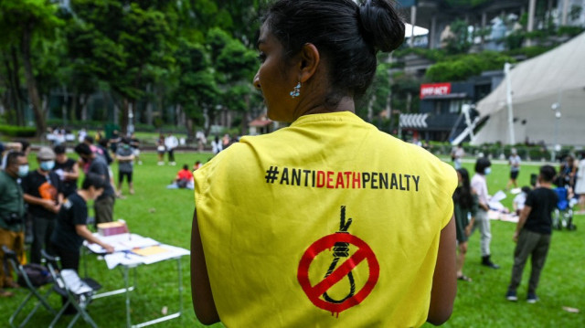 Un militant porte un T-shirt avec une pancarte contre la peine de mort lors d'une manifestation contre la peine de mort au Speakers' Corner à Singapour.