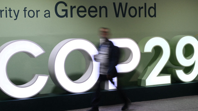 Les participants passent devant le logo de la COP29 lors de la Conférence des Nations Unies sur le changement climatique (COP29) à Bakou, en Azerbaïdjan, le 21 novembre 2024.