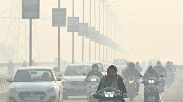 Des banlieusards se frayent un chemin dans une rue d'Amritsar au milieu d'un épais smog, le 21 novembre 2024.