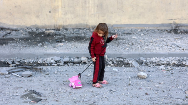 Une petite fille palestinienne joue dans une rue remplie de débris à cause des attaques incessantes de l'armée d'occupation israélienne à Jabalia, dans le nord de la bande de Gaza, le 20 novembre 2024.