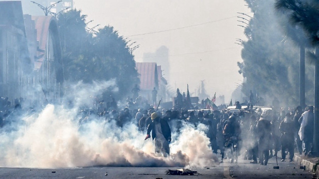 Des policiers tirent des grenades lacrymogènes pour disperser des partisans du parti Pakistan Tehreek-e-Insaf (PTI) lors d'une manifestation réclamant la libération de l'ancien premier ministre Imran Khan, dans la zone rouge d'Islamabad, le 26 novembre 2024.