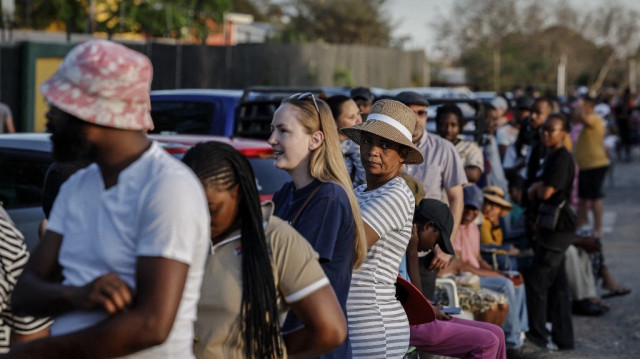 Les électeurs font la queue dans un bureau de vote à Hochland Park, Windhoek, le 27 novembre 2024 avant l'ouverture des bureaux de vote lors des élections générales en Namibie. 