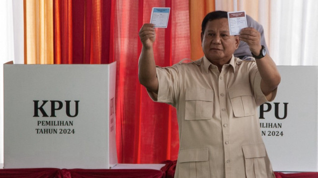 Le président indonésien Prabowo Subianto montre les bulletins de vote lors des élections régionales simultanées à Bogor, Java Ouest, le 27 novembre 2024.