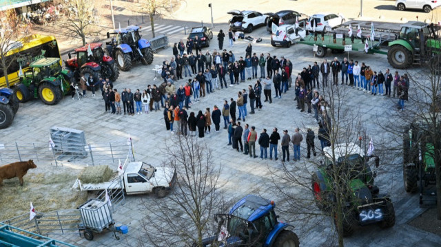 Des agriculteurs forment un SOS, alors que des membres du syndicat Jeunes Agriculteurs (JA) et de la Fédération Départementale des Syndicats d'Exploitants Agricoles (FDSEA) participent à une transhumance urbaine de vaches à Rodez, dans le sud-ouest de la France, le 27 novembre 2024.