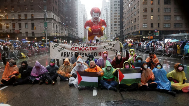 Le groupe de manifestants contre le génocide à Gaza, assis devant un ballon McDonald's lors de la Thanksgiving Day March, à Manhattan, le 28 novembre 2024.
