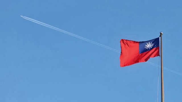 Un avion survole le drapeau national de Taïwan qui flotte sur le boulevard de la démocratie au Chiang Kai-shek Memorial Hall à Taipei.