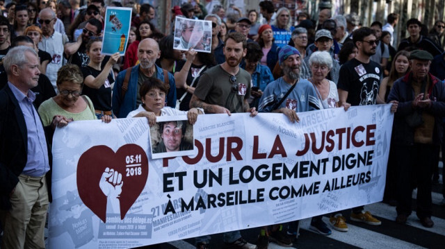 Des manifestants lors d'un rassemblement pour réclamer le droit à un logement décent et rendre hommage aux victimes, quelques jours avant l'ouverture du procès sur l'effondrement des deux immeubles de la rue d'Aubagne où huit personnes ont perdu la vie le 5 novembre 2018, à Marseille, dans le sud de la France, le 3 novembre 2024. 