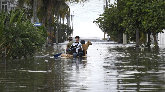 Des personnes traversent une rue inondée sur un radeau en bois à La Havane, le 6 février 2024.