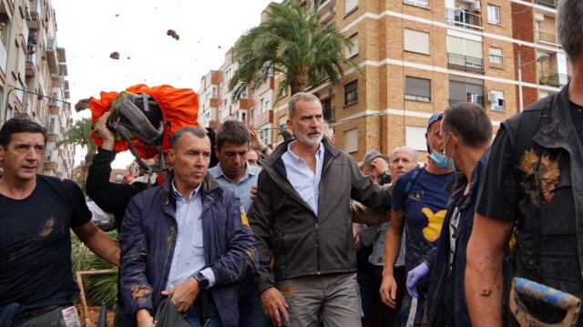 Le roi Felipe VI d'Espagne (C) confronté à des habitants en colère qui lui jettent de la boue et divers objets lors de sa visite à Paiporta, dans la région de Valence, le 3 novembre 2024, suite à des inondations meurtrières dévastatrices dans le pays.
