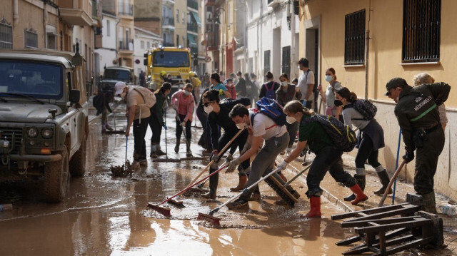 Des habitants dégagent la boue et les débris d'une rue à Aldaia, dans la région de Valence, dans l'est de l'Espagne, le 5 novembre 2024, après des inondations dévastatrices.