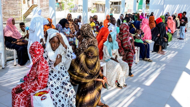 Des femmes avec des enfants attendent à l'ombre pour recevoir des soins médicaux à l'extérieur de l'hôpital pédiatrique italien à Port-Soudan, le 8 octobre 2024.