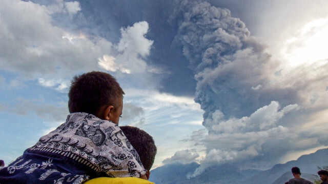 Des habitants observent l'éruption du mont Lewotobi Laki Laki depuis le village d'Eputobi à Titihena, dans l'est de Nusa Tenggara, le 8 novembre 2024.