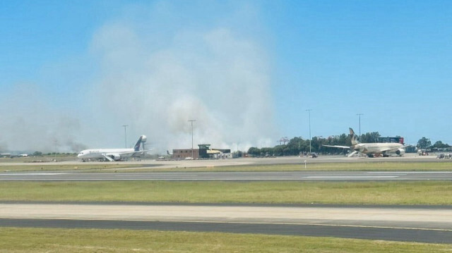 Un vol Qantas à destination de Brisbane a été contraint d'effectuer un atterrissage d'urgence à l'aéroport de Sydney, ce qui pourrait être à l'origine d'un important feu d'herbe près de la piste.