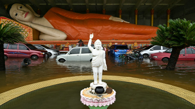 Une statue de Bouddha couché est entourée par les eaux de crue au Wat Phothivihan (temple du Bouddha endormi) après de fortes pluies à Tumpat, dans l'État de Kelantan, en Malaisie, le 1er décembre 2024. Plus de 150 000 personnes ont été contraintes de quitter leur domicile à la suite d'inondations massives causées par des pluies incessantes qui ont balayé les États du nord de la Malaisie, ont déclaré les responsables de la gestion des catastrophes le 30 novembre.