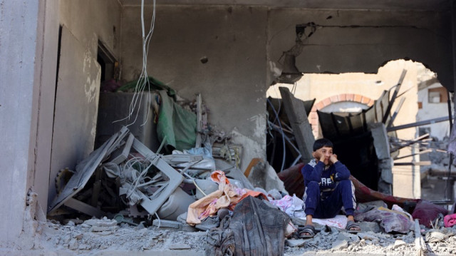 Un garçon palestinien observe depuis une pièce endommagée adjacente à un bâtiment détruit lors d'une frappe israélienne sur le quartier de Shujaiyah dans la ville de Gaza, dans le nord de la bande de Gaza, le 30 novembre 2024.