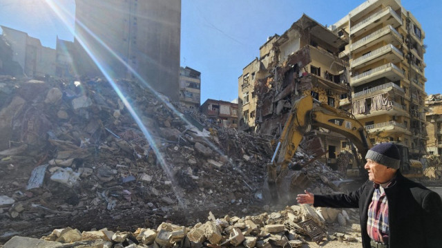 Naji Zein, un Libanais de 72 ans qui a fui sa maison pendant la guerre entre Israël et le Hezbollah, regarde une pelleteuse creuser dans les décombres d'un bâtiment où vivait son ami et voisin à Haret Hreik, dans la banlieue sud de Beyrouth, le 30 novembre 2024.